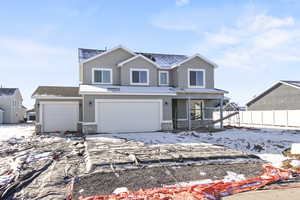 Traditional home featuring stone siding, stucco siding, a garage, and a porch