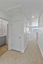 Hall featuring light carpet and an upstairs landing