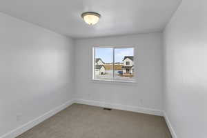 Carpeted empty room featuring baseboards