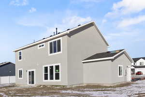 Snow covered house with stucco siding