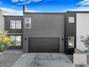 Contemporary home with a garage, stucco siding, and concrete driveway