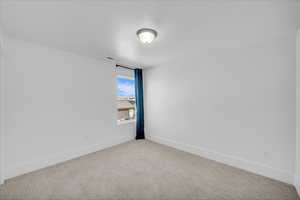 Carpeted spare room with baseboards