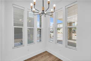 Unfurnished dining area featuring light wood-type flooring and baseboards