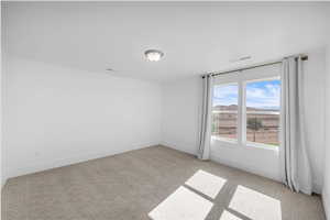 Empty room featuring light carpet