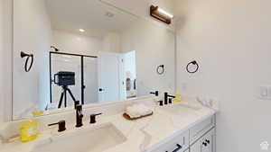 Full bath featuring double vanity, a shower stall, and recessed lighting