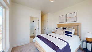 Bedroom featuring light colored carpet and baseboards