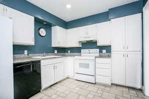 Kitchen featuring white appliances, white cabinets, under cabinet range hood, light stone counters, and recessed lighting