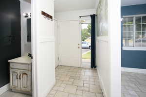 Foyer with ornamental molding and stone tile floors