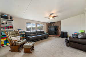 Living room with carpet flooring, ceiling fan, and lofted ceiling