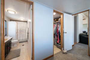 Full bath with vanity, a walk in closet, light tile patterned flooring, and shower / tub combo with curtain