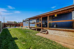 Rear view of house with covered porch and a fenced backyard