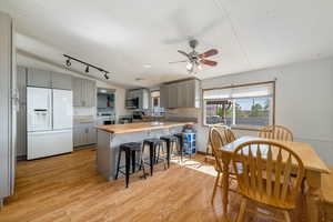 Kitchen with gray cabinets, lofted ceiling, appliances with stainless steel finishes, light wood-style flooring, and butcher block counters