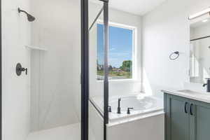 Bathroom featuring a shower stall, vanity, and a bath