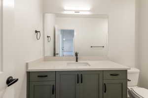 Half bathroom featuring vanity and toilet