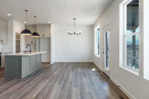 Kitchen with gray cabinets, pendant lighting, a chandelier, dark wood-style flooring, and recessed lighting