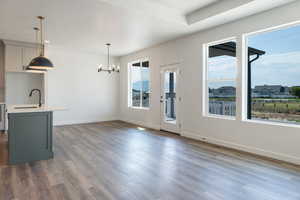 Unfurnished living room featuring dark wood-type flooring and a chandelier