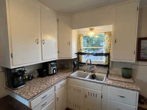 Kitchen with white cabinetry and light countertops