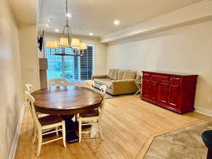 Dining space with recessed lighting, a chandelier, light wood-type flooring, and ornamental molding