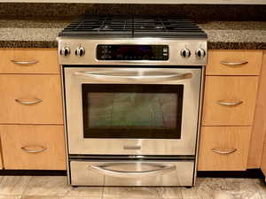Kitchen with stainless steel appliances, light brown cabinets, and light tile patterned flooring