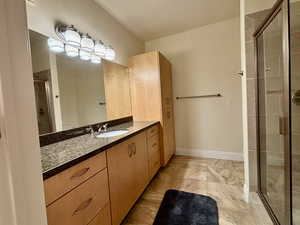 Bathroom with a shower stall, vanity, and crown molding