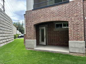 Back of house with brick siding and a yard