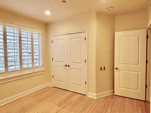 Unfurnished bedroom featuring a closet and light wood-type flooring