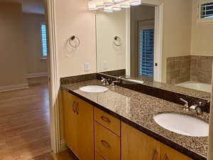 Full bath with double vanity, a garden tub, crown molding, and light tile patterned floors
