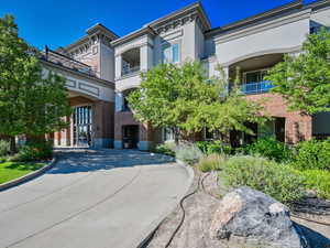 Italianate-style house with stucco siding, brick siding, and a balcony