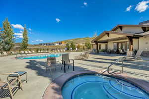 Community pool featuring a patio area, a community hot tub, and a mountain view