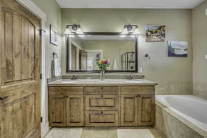 Full bathroom with double vanity, a bath, light tile patterned flooring, and a shower stall