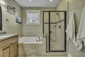 Full bath with a garden tub, vanity, a shower stall, and recessed lighting