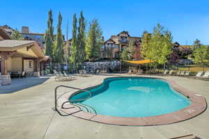Community pool featuring a patio area and a residential view