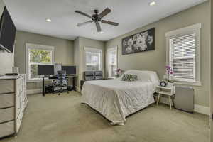 Bedroom featuring light colored carpet, an office area, recessed lighting, and a ceiling fan