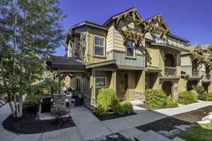 Craftsman-style home with board and batten siding, stone siding, and a shingled roof