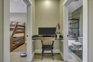 Home office with light carpet and baseboards