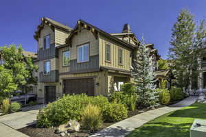 Craftsman-style house with board and batten siding, a garage, concrete driveway, stone siding, and a shingled roof