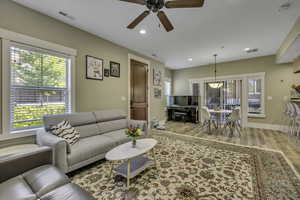 Living room with light wood-type flooring, recessed lighting, and a ceiling fan