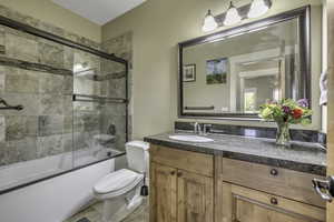 Bathroom featuring vanity, combined bath / shower with glass door, and light tile patterned floors