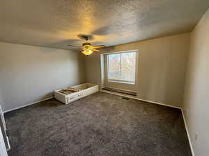 Empty room featuring carpet floors, a textured ceiling, and ceiling fan