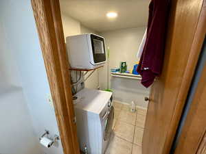 Laundry room with light tile patterned floors