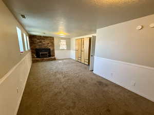 Unfurnished living room with carpet and a textured ceiling