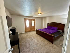 Bedroom featuring a textured ceiling and carpet floors