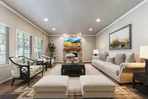 Living room featuring ornamental molding, recessed lighting, and a fireplace