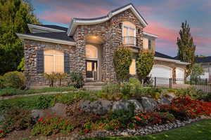 View of front of house with stone siding and a garage