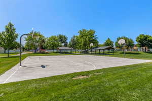 View of basketball court with community basketball court and a lawn