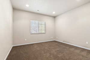 Unfurnished room with dark carpet and recessed lighting