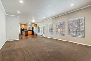 Family room featuring recessed lighting, dark colored carpet, crown molding, and a textured ceiling