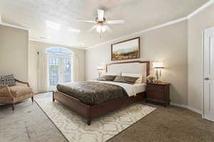 Carpeted bedroom with ornamental molding and a ceiling fan