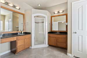 Full bathroom with a shower stall and two vanities as well as makeup vanity