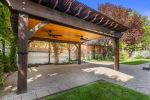 Fenced backyard featuring a patio and a ceiling fan